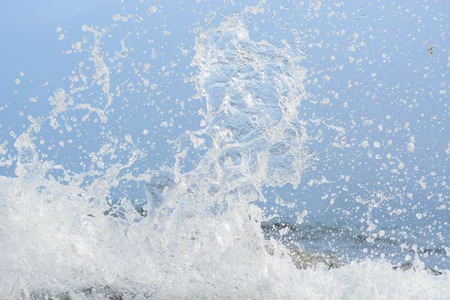 The wave breaks on the rock and forms a lot of sprayの写真素材