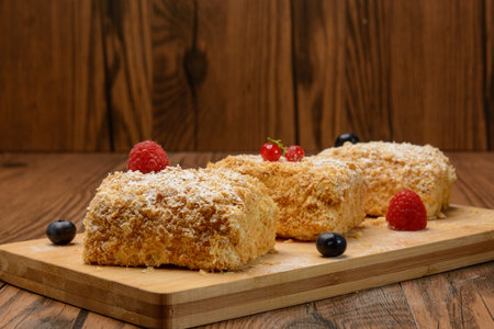 Cakes with berries on the board. Wood background