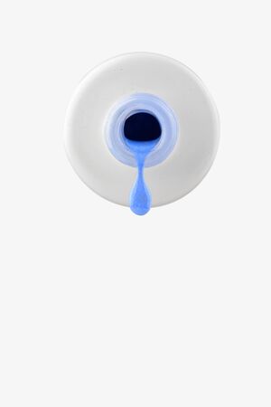 Blue gel polish with a shimmer dripping from a bottle on a white background.の写真素材