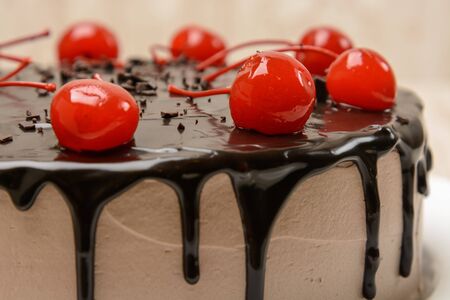 Chocolate covered cake decorated with coctail cherries.の写真素材