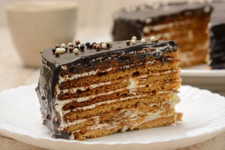 Puff cake with chocolate. Sliced piece on a plate. Wood backgroundの写真素材