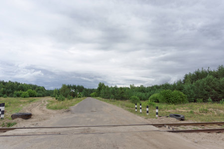 Crossing the old railway line and the country road in the forest. Russiaの写真素材