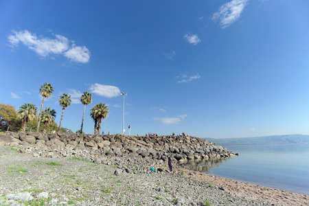 Israel. - February 17.2017. Tourists are walking on the shore on the stone embankment of the Sea of Galilee in Israel.のeditorial素材