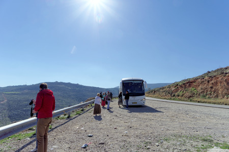 Lower Galilee, Israel. - February 18.2017. Tourists left the stopped bus to stretch their legs and take a photo on road in the Lower Galilee.のeditorial素材