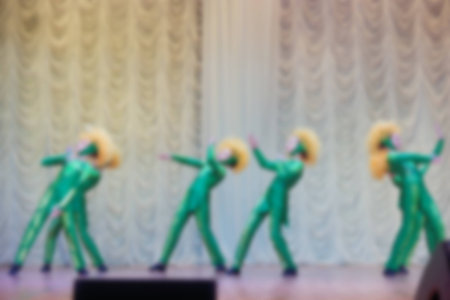 Folk dances of children and teens theme abstract blur background with bokeh effect. Teens in bright white folk costumes dance Russian folk dance.の写真素材