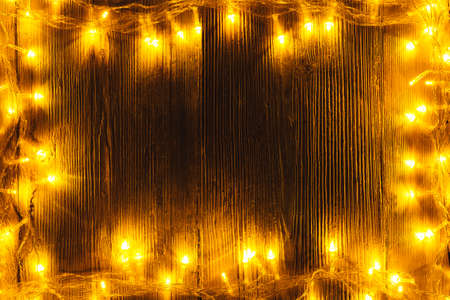 Garland Lights Frame Wood, Blank Wooden Board, Holiday Yellow Light on Dark Brown Borderの写真素材