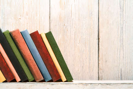 Books Wood Shelf, Old Spines Covers on White Vintage Wooden Wallの写真素材