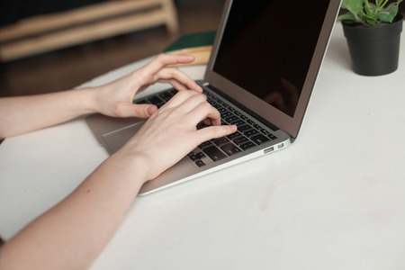 girl with laptop typing and thinkingの写真素材