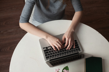 girl with laptop typing and thinkingの写真素材