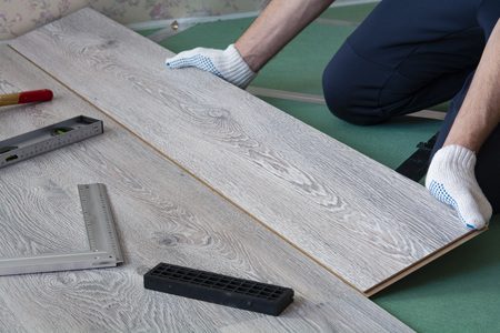 man installs new laminate flooringの写真素材