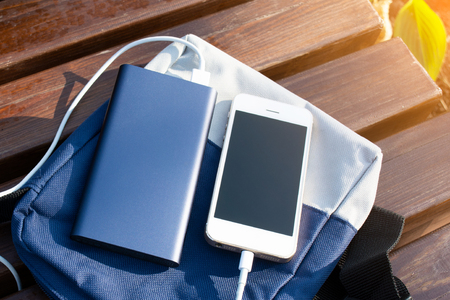 Bank of power and phone on the benchの写真素材