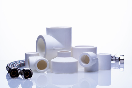 set of fittings for PVC pipes and reinforced water hose on a white backgroundの写真素材