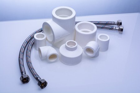 set of fittings for PVC pipes and reinforced water hose on a white backgroundの写真素材