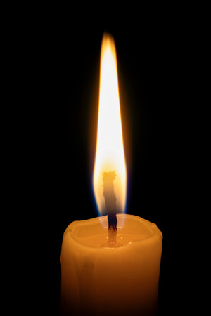 a lonely burning candle in the darknessの写真素材