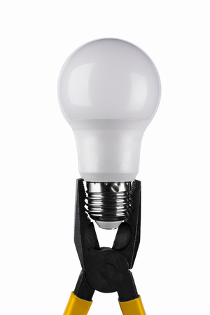 yellow pliers hold energy-saving light bulbの写真素材