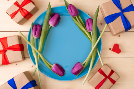 pink tulips in a plate with romantic gifts aroundの写真素材
