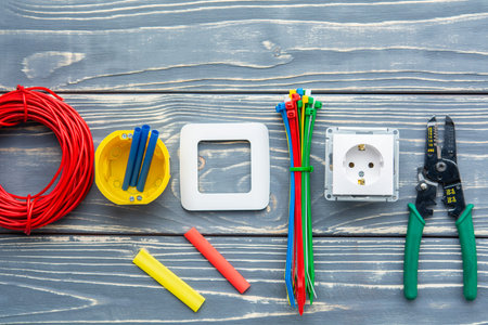 Electrician's supplies on gray wooden background