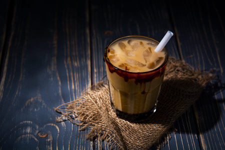 ice coffee with milk and caramel on dark background