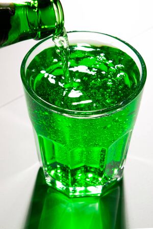 glass with green soda and bottleの写真素材