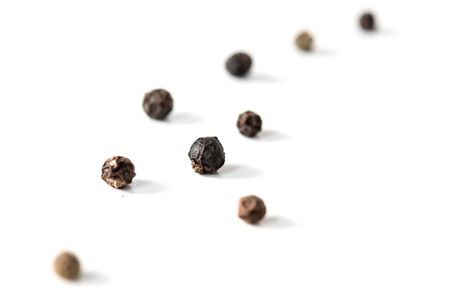 grains of black pepper on a white backgroundの写真素材