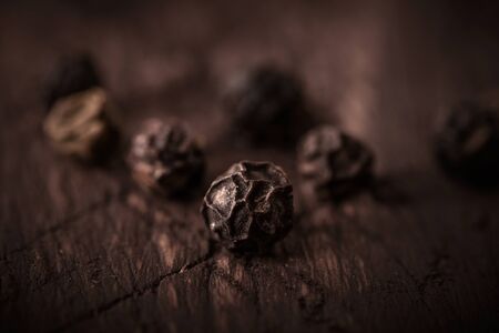 black pepper grains on wooden background close-upの写真素材
