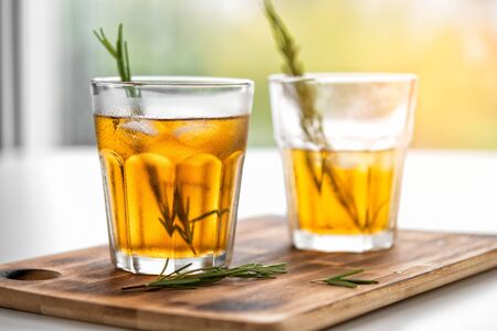 glasses of soda with lemon and rosemary on a bamboo boardの写真素材