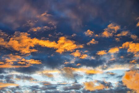 Dramatic sky at sunset or sunrise with red and orange clouds. Variegated colored clouds at the evening sunset of the summer sky.の写真素材