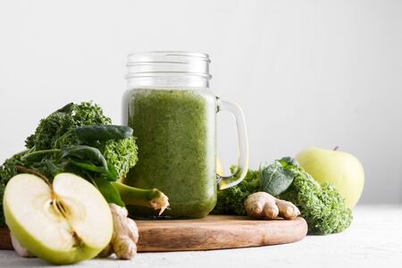 Freshly prepared jar of green smoothie, closeup. Fresh vegetable smoothie on a light background. Vegetable smoothie with spinach and kale cabbage.の写真素材
