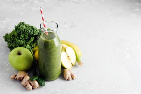 Freshly made bottle of green smoothie, closeup. Fresh vegetable smoothie on a light background. Vegetable smoothie with spinach and kale cabbage.の写真素材