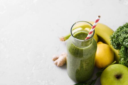 Freshly made bottle of green smoothie, closeup. Fresh vegetable smoothie on a light background. Vegetable smoothie with spinach and kale cabbage.の写真素材