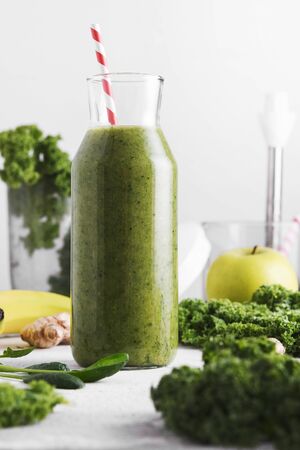 Freshly made bottle of green smoothie, closeup. Fresh vegetable smoothie on a light background. Vegetable smoothie with spinach and kale cabbage.の写真素材