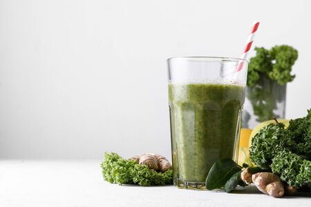 Freshly prepared glass of green smoothie, closeup. Fresh vegetable smoothie on a light background. Vegetable smoothie with spinach and kale cabbage.の写真素材