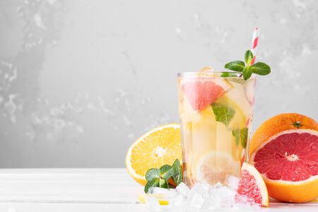 Summer refreshing lemonade with mint on a light background. A glass of citrus cocktail in a light key. Close up. Summer Vitamin cocktail of orange, lemon and grapefruit.の写真素材