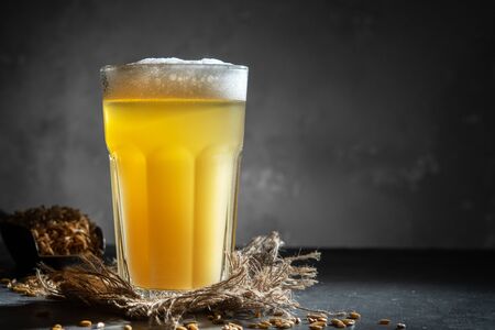 Glass of homemade beer on a concrete background. Glass of craft beer on a dark background.の写真素材