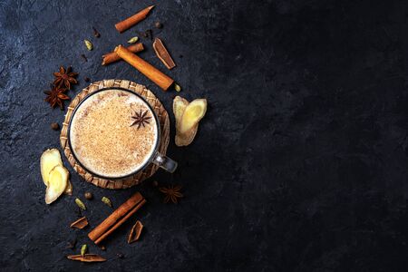 Masala tea with cinnamon and anise on a blue concrete table. A cup of masala tea with spices on the concrete table. Top view.の写真素材
