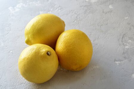 Three lemons on a grey concrete background with a copy of space.の写真素材