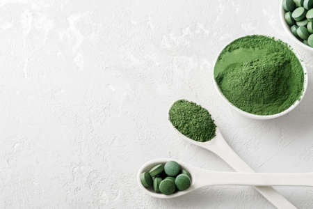 Chlorella or spirulina in the form of tablets and powder on a gray concrete background.の写真素材