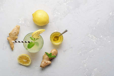 Glass with ginger water and ingredients on grey concrete surface. Top view.の写真素材