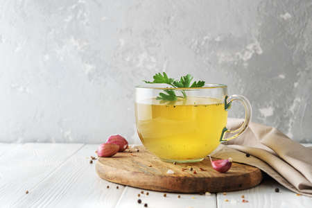 Cup of homemade beef bone broth on white wooden background with a copy of space.の写真素材