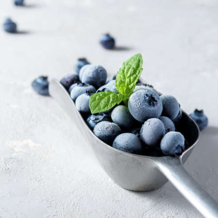 A scoop of frozen blueberries on a concrete surface.の写真素材