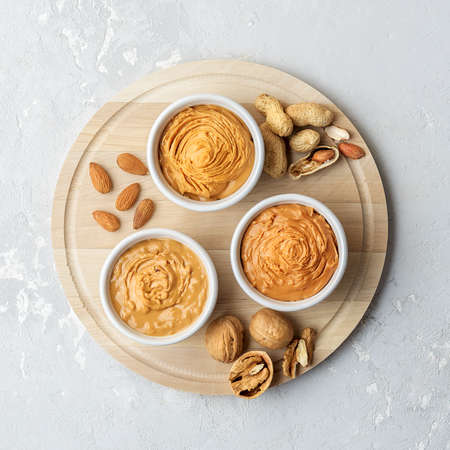 Walnut butter made of peanuts, almonds and walnut on a gray background.の写真素材