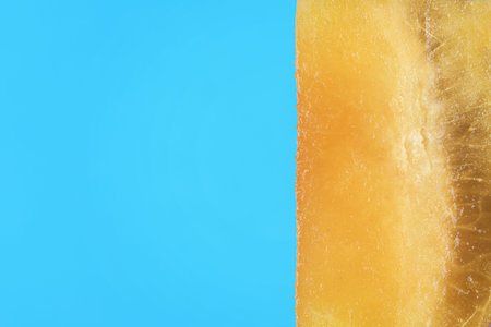 Cut off a piece of plum close-up on a blue background with copies of space.