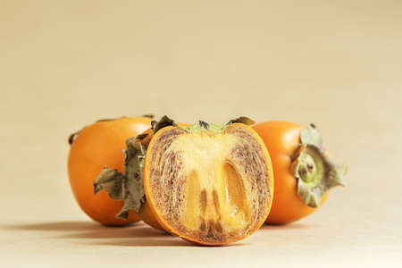 Juicy persimmon on a beige bed background.の写真素材