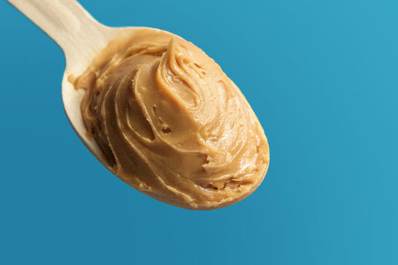 Spoon of nut oil on a blue background.の写真素材