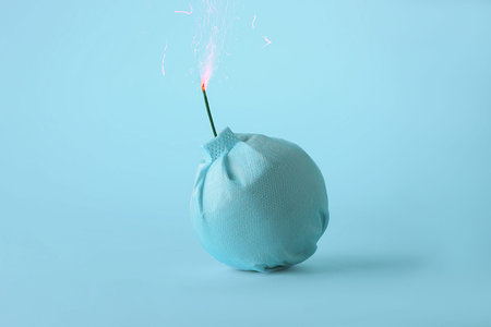 The creative concept of the  virus epidemic. Medical mask in the form of a bomb on a blue...