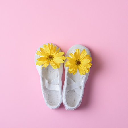 White ballet flats with yellow flowers on a pink background. Top view.の写真素材