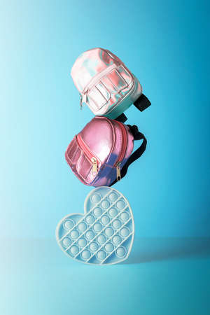 The creative concept of back to school. School colored backpacks and fidget toys balance each other out.の写真素材