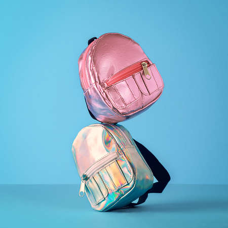 The creative concept of back to school. School backpacks balancing on a blue background.の写真素材