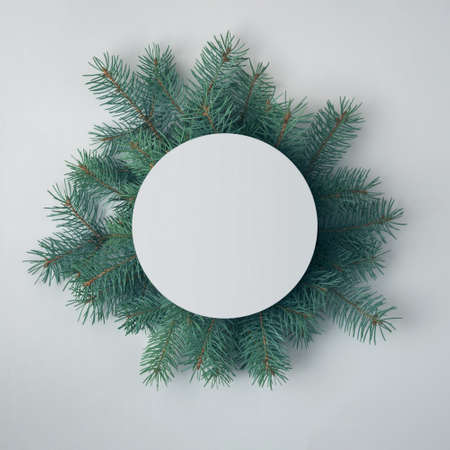 Creative Christmas composition of spruce branches and a round blank card. Christmas layout.の写真素材