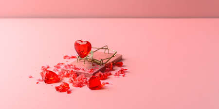 Glass heart in mousetrap on pink background with copy space. A creative concept for Valentine's Day.の写真素材